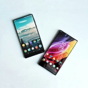two cell phones side by side on a white surface