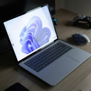 a laptop computer sitting on top of a wooden desk