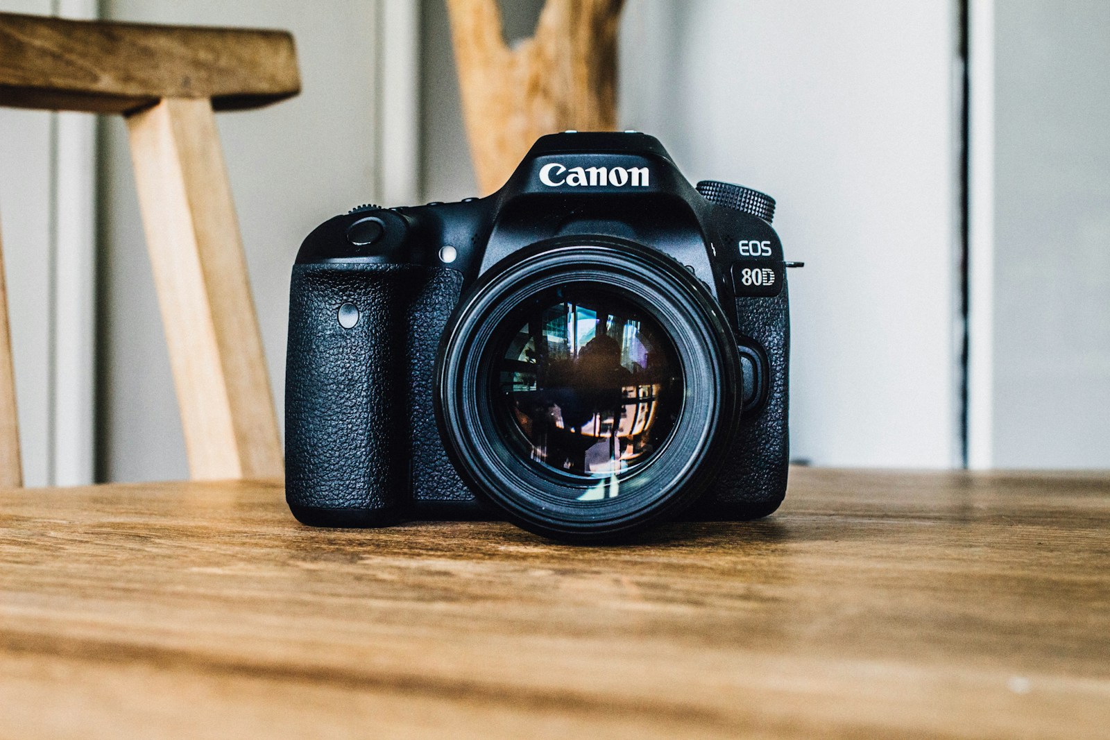 Photo by Hanson Lu Canon DSLR camera on brown wooden table during daytime